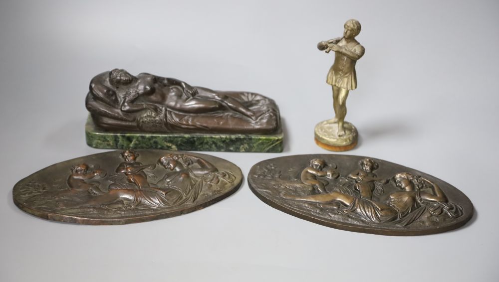 A bronze of a reclining female nude, a pair of plaques and a boy musician